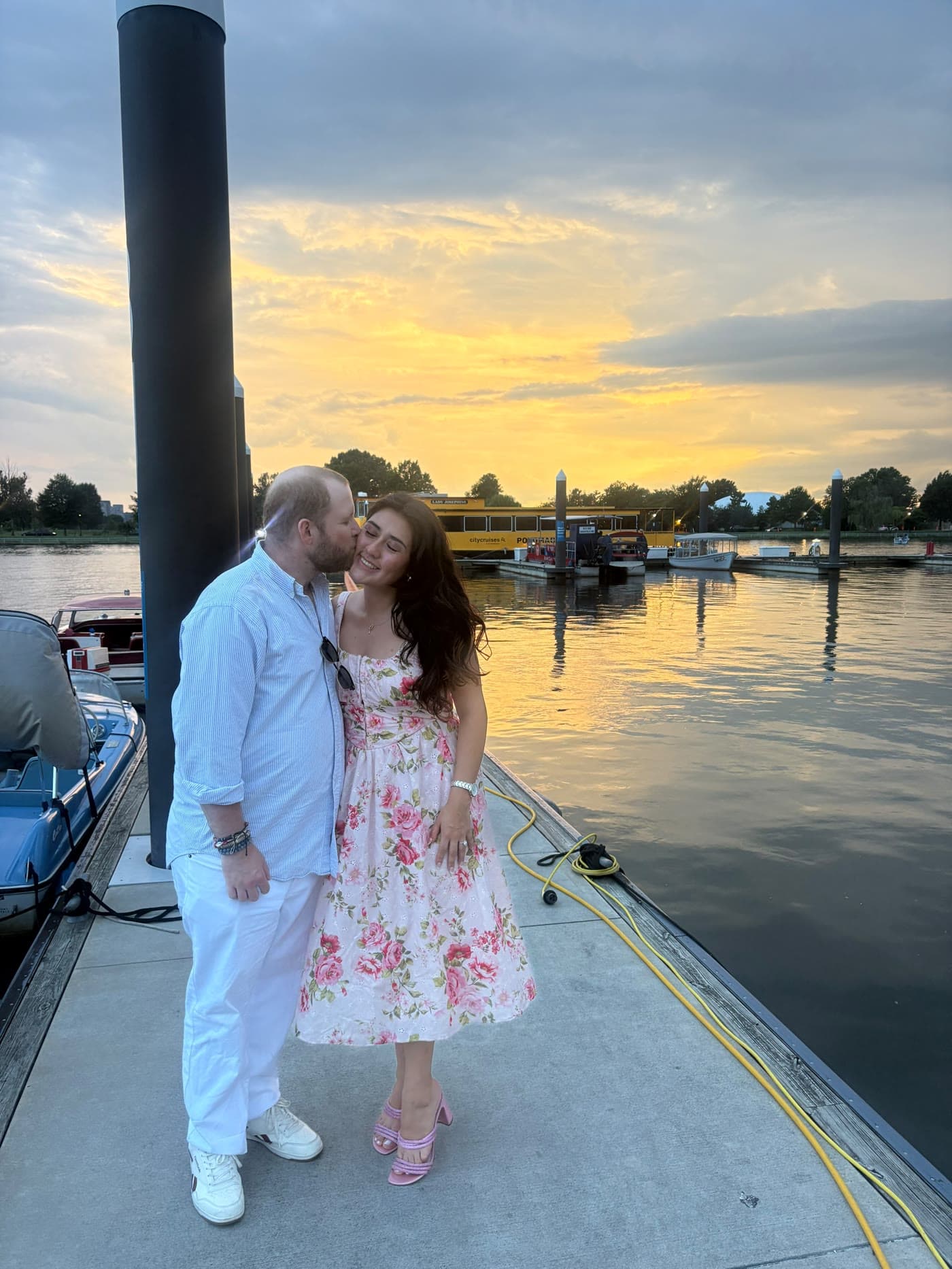Brenden kisses Nicole on a dock at sunset