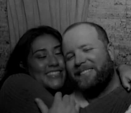 Brenden and Nicole hugging and smiling in a photo booth